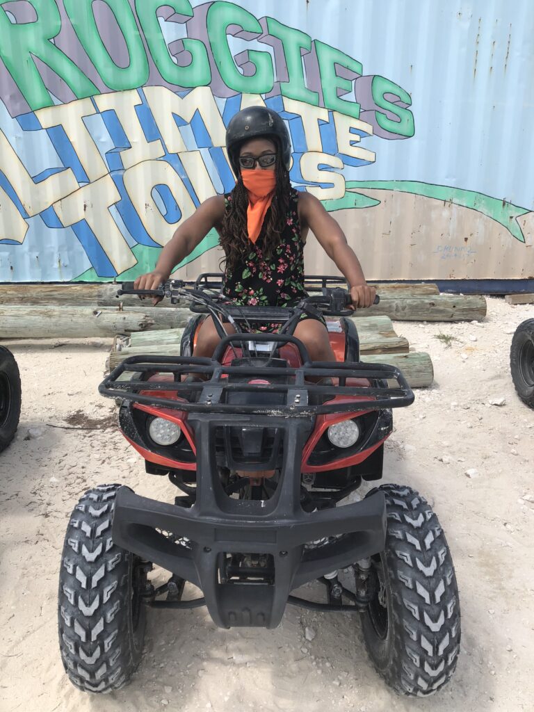 A woman sitting on the back of an atv.