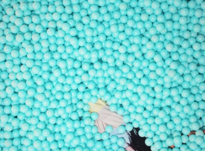 A ball pit filled with blue balls and people