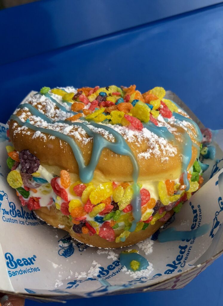 A donut with frosting and colorful candy on top.