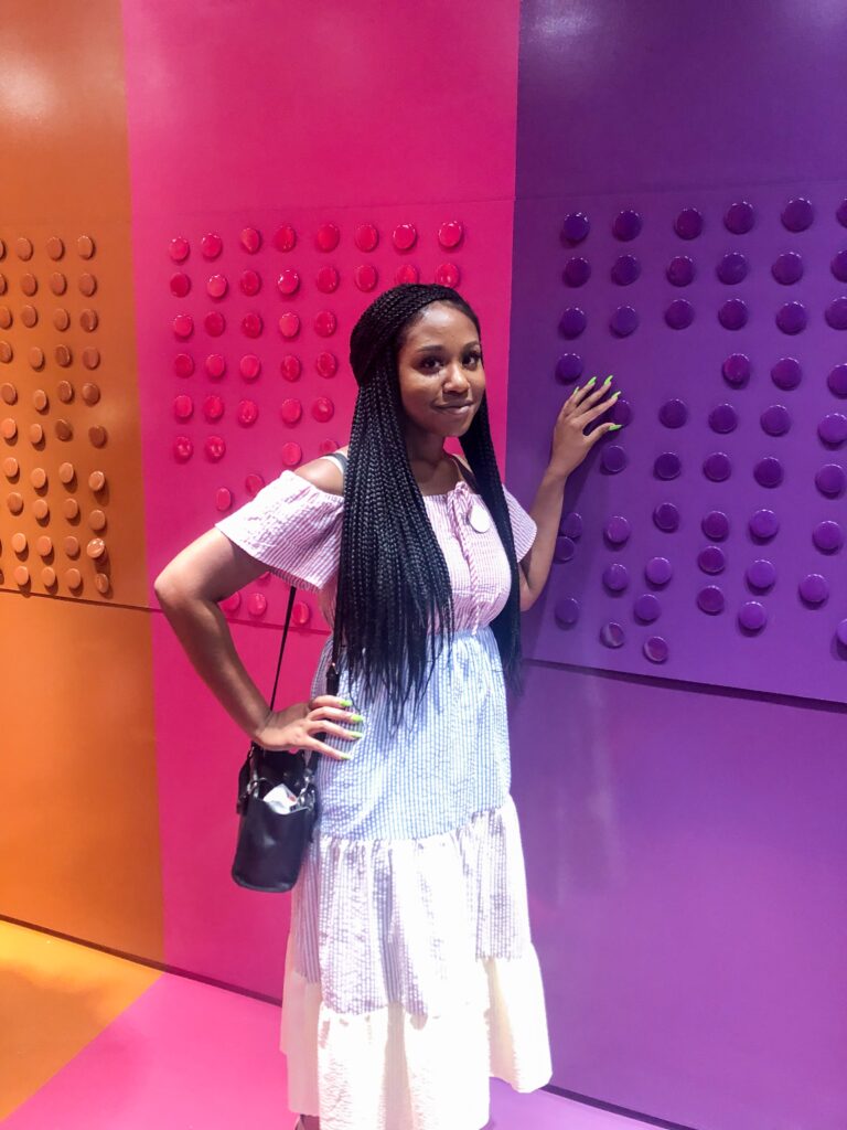 A woman standing in front of a wall with colored walls.