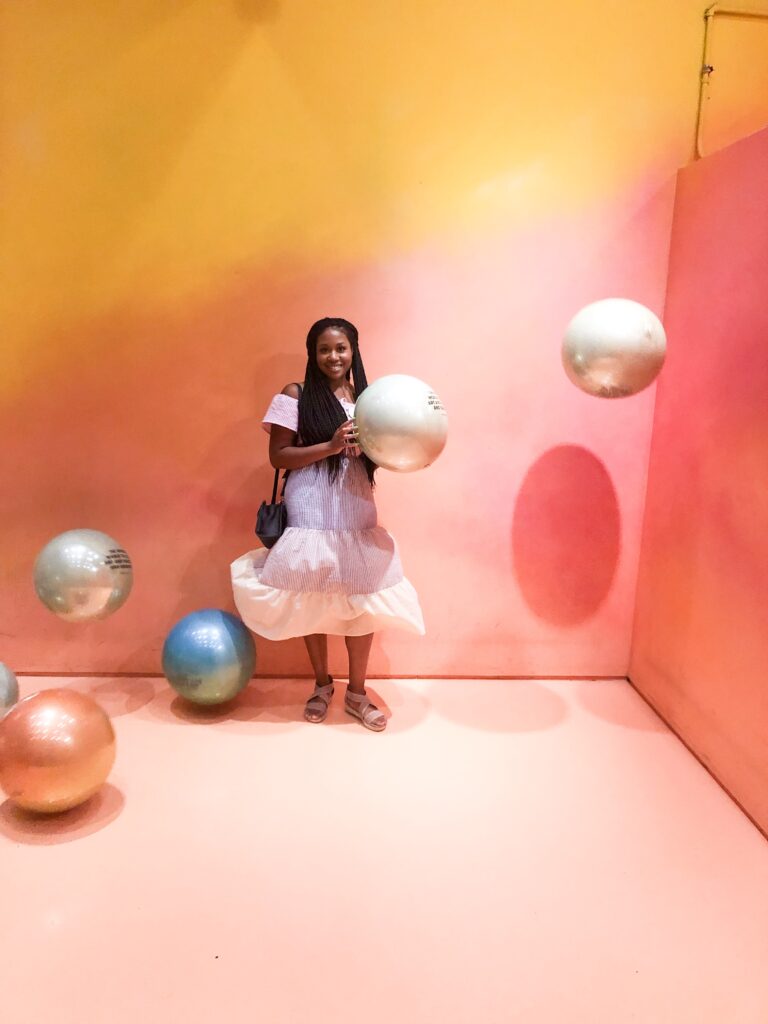 A woman standing in front of some balls