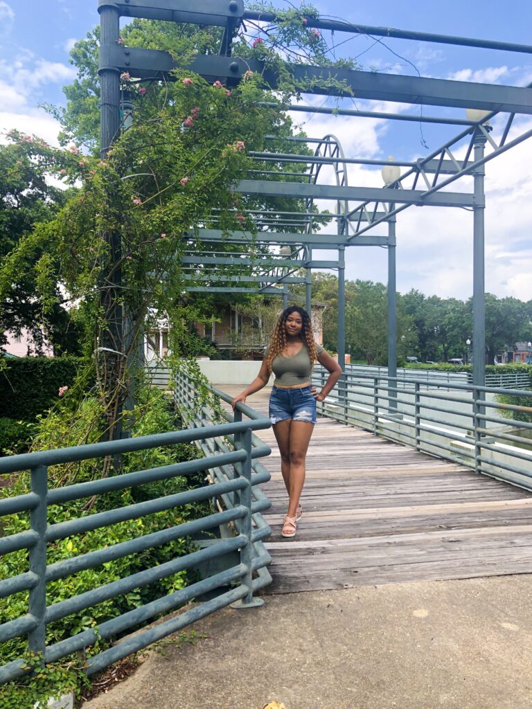 A woman in a bikini is walking across a bridge.