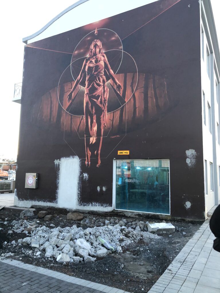 A large mural of a woman on the side of a building.